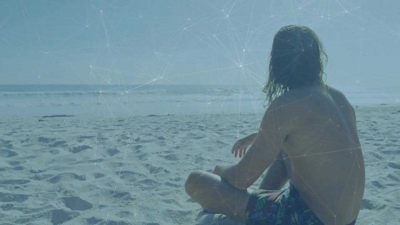 Bagnante che cammina su una spiaggia sabbiosa, seduto mentre un'interfaccia di rete illustra un collegamento tecnologico sull'oceano