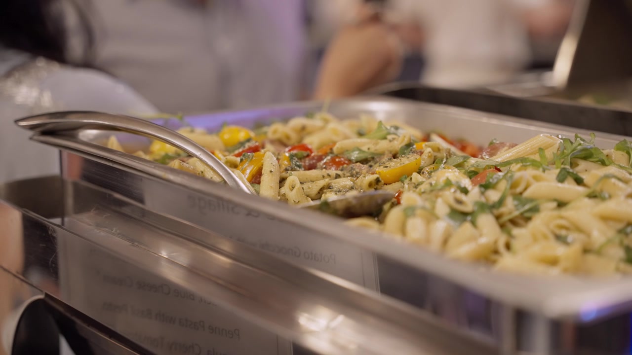 Penne makarna, bir davet etkinliğinde ısıtıcı bir tepsi içinde duruyor