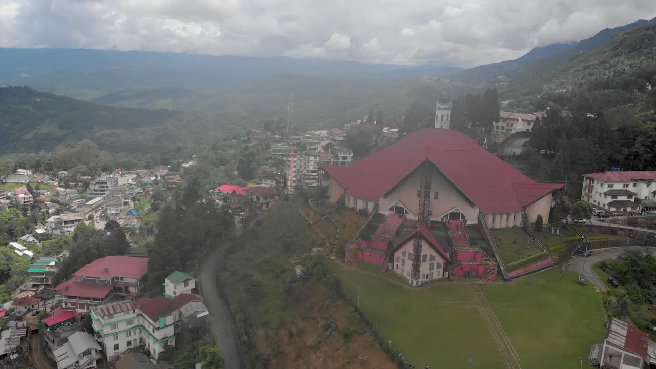 인도, 나가랜드, 안개로 뒤덮인 나가 건축물에 지어진 코히마 대성당의 4k 공중 나선형 샷