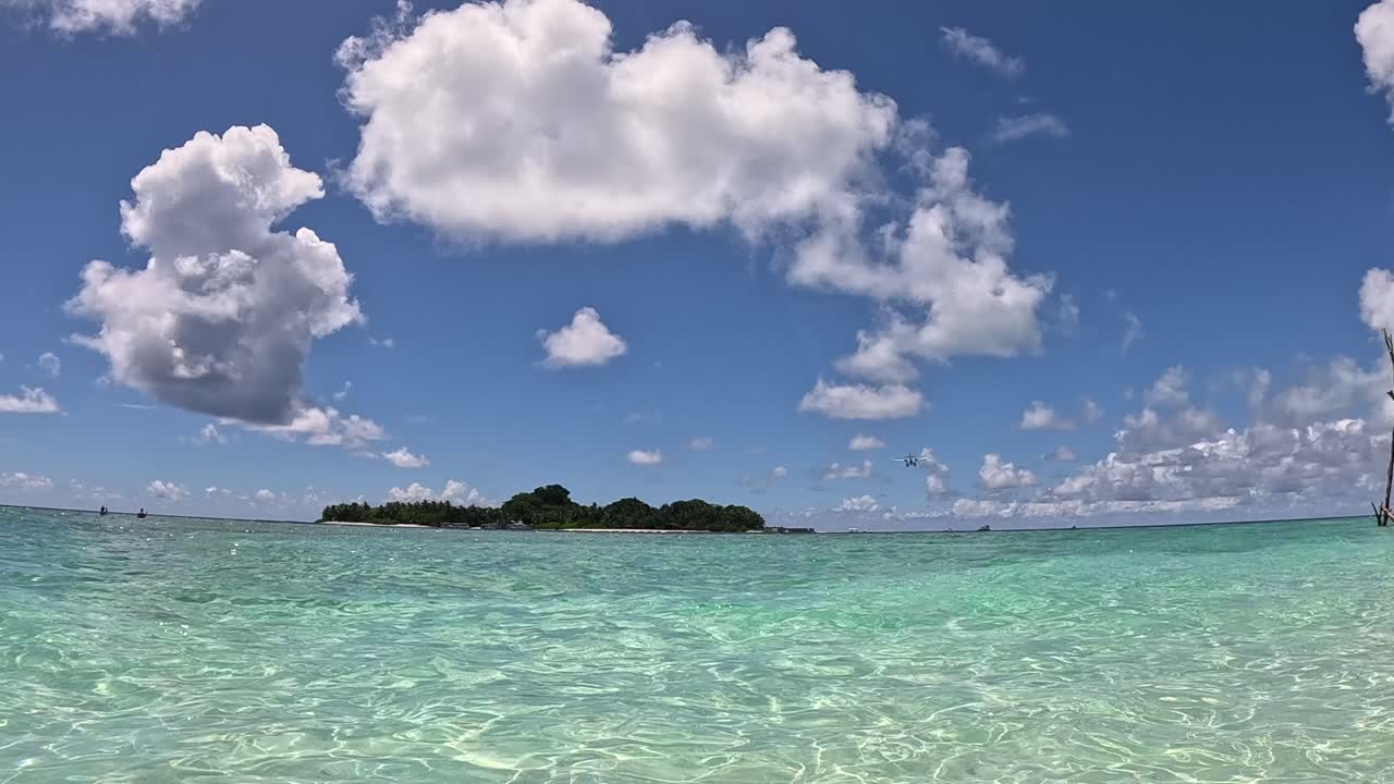 Sea plane airplane flying over tropical island in the maldives
