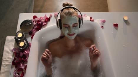 Caucasian-woman-taking-bath-while-listening-music-in-hotel