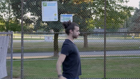 Side-view-close-up-of-a-young-Caucasian-man-stretching-body-and-getting-ready-for-tennis-practice