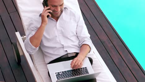 Man-using-laptop-on-sun-lounger