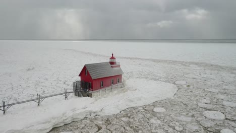 Grand-Haven,-Michigan-lighthouse-in-the-winter-at-Lake-Michigan-with-drone-fly-over