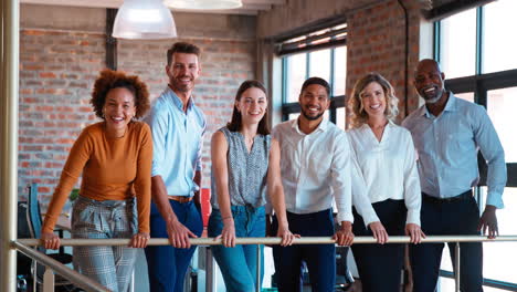 Portrait-Of-Smiling-Multi-Cultural-Business-Team-Standing-Together-In-Modern-Office