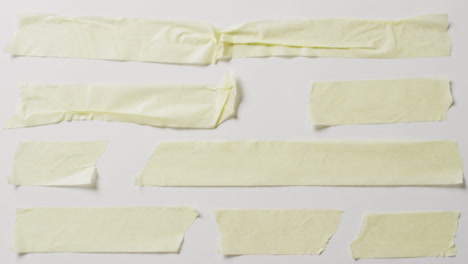 video de un primer plano de varias piezas rasgadas de papel amarillo con espacio de copia en un fondo blanco