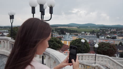 woman taking a photo of a cityscape