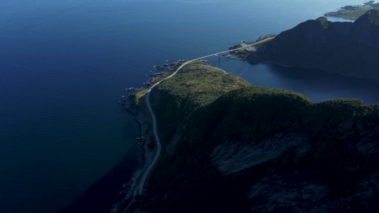 바다가 내려다보이는 산 위를 날고 산의 먹이에서 풍경을 가로지르는 작은 해안도로