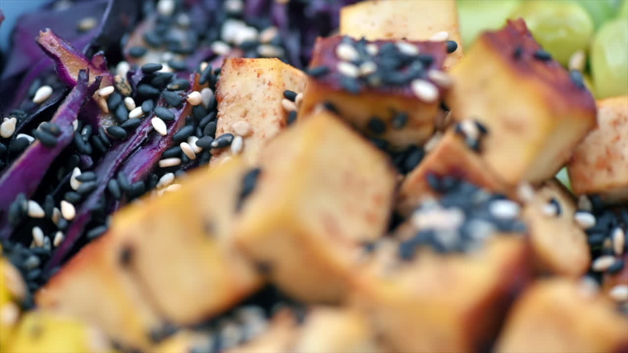 Close view of vegan poke with vegetables, tofu and seeds in a bowl