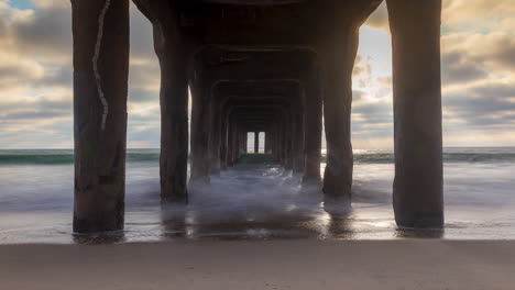 timelapse - sunset view under the pier at manhattan beach, california, usa