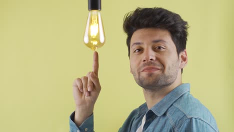 su hombre pensativo tiene una idea, una lámpara de idea simbólica se enciende sobre su cabeza.