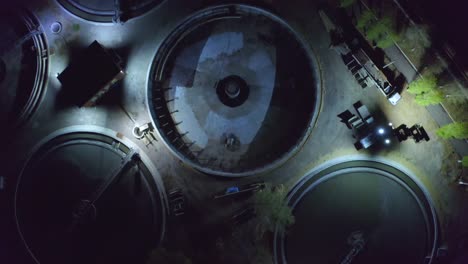 aerial top view of sewage treatment plant with round sedimentation tanks at night