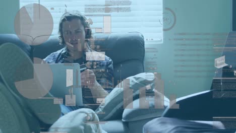 animación de la interfaz infográfica moviéndose sobre un hombre de negocios caucásico trabajando en una computadora portátil en el sofá