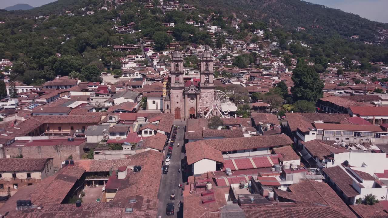 A drone flies over the houses in the center of Valle de Bravo, approaching the two towers of the Parish of San Francisco de As&iacute;s