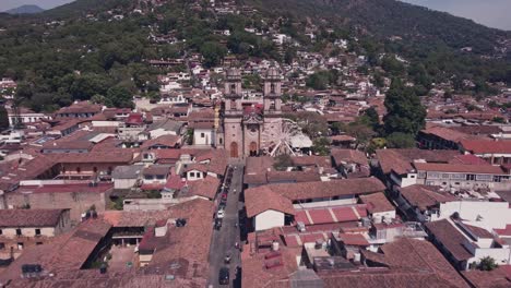 Un-Dron-Sobrevuela-Las-Casas-Del-Centro-De-Valle-De-Bravo,-Acercándose-A-Las-Dos-Torres-De-La-Parroquia-De-San-Francisco-De-Asís