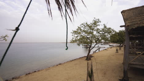 pueblo africano de senegal con construcción de cabañas de madera frente a un lago explorando la visita al continente africano en un área remota