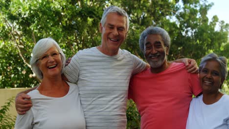 Senior-friends-standing-together-with-arm-around-in-garden-4k