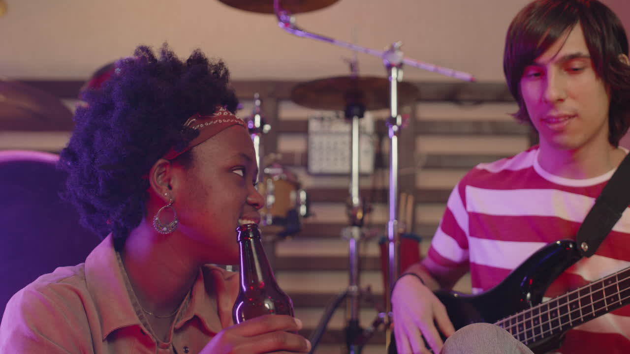 Boy Playing Guitar And Talking With Friend During A Rehearsal In Recording Studio