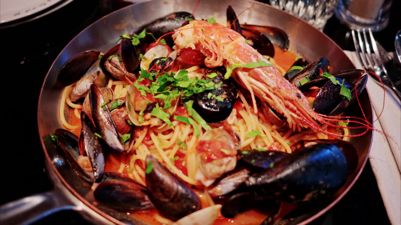 Close up of pasta with tomato sauce and mussels in a pan
