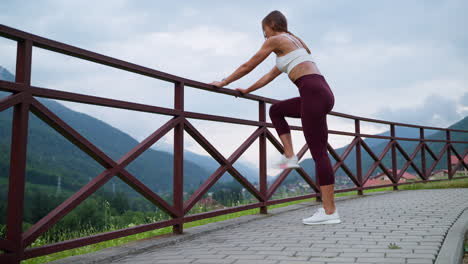 mujer estirándose al aire libre en una vista de montaña