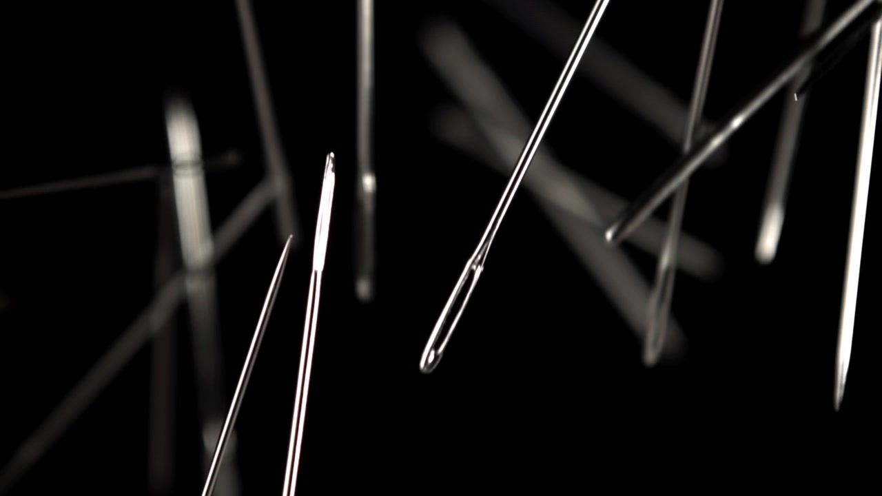 Close-up of Sewing Needles Falling in Slow Motion on Black Background