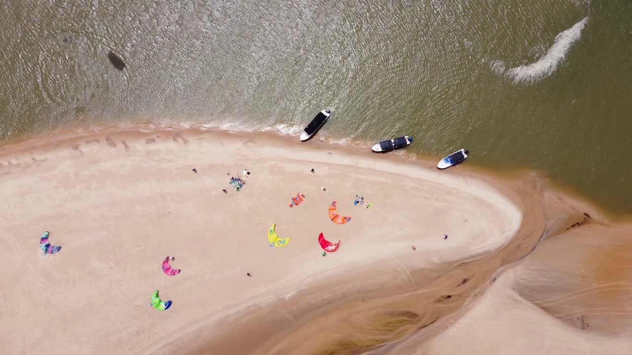 perspectiva a vista de pájaro de un grupo de cometas en la playa preparando cometas