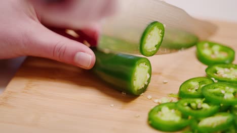 Caucasian-female-hand-slicing-jalapeños-in-slow-motion-three-quarter-angle