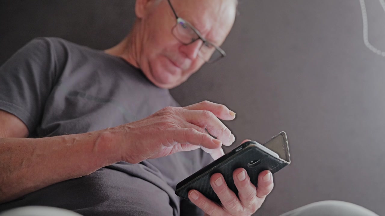 Ikääntynyt mies sopeutuu digitaaliseen elämään mobiiliteknologian käytön avulla.