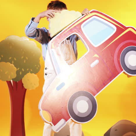 little boy with a red car in the studio. yellow background. bright scenery. square video