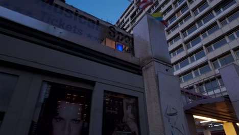 evening scene of an illuminated u-bahn station entrance in berlin, germany. people walking nearby creating a lively urban atmosphere.