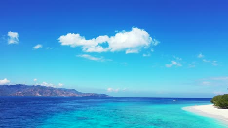 vivid colors of amazing seascape with bright blue sky with static clouds hanging over blue turquoise sea between two tropical islands in indonesia