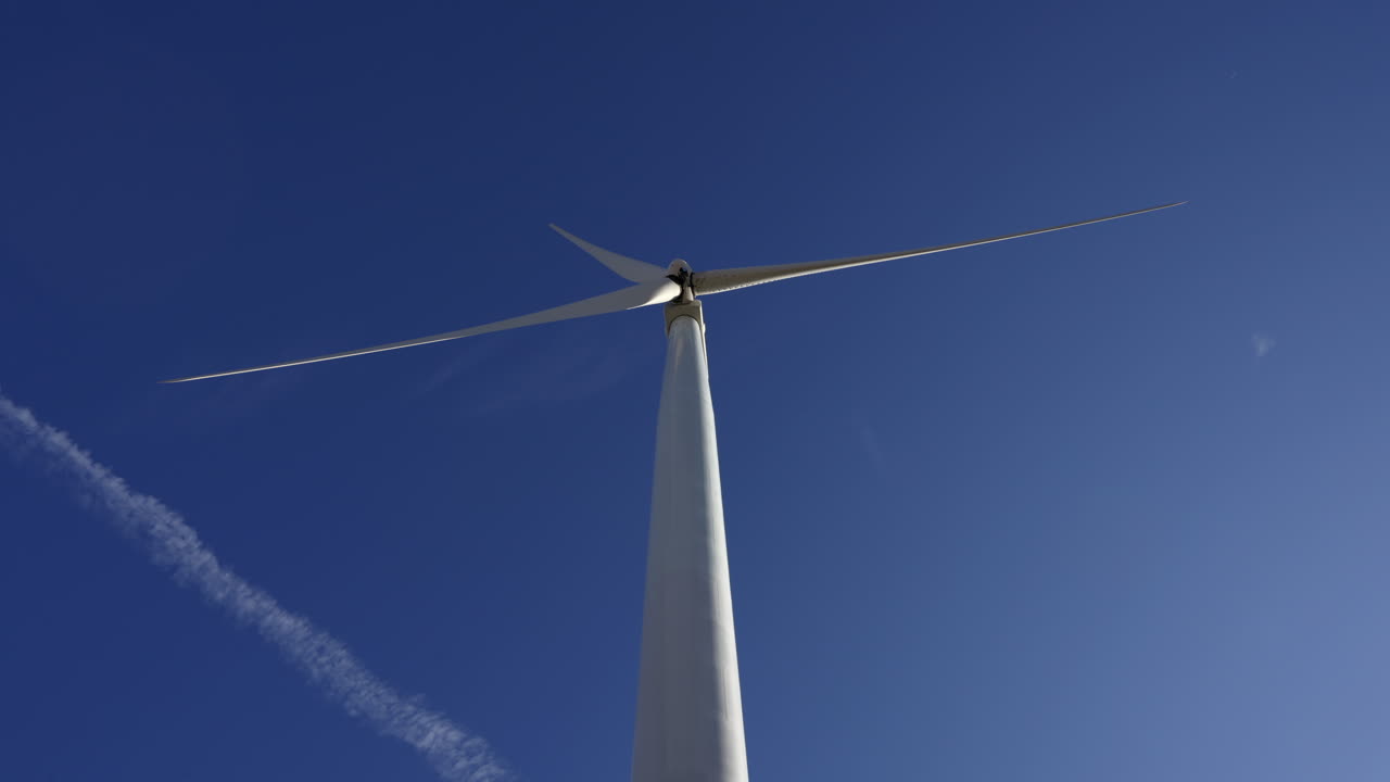 Towering Windmill Farm Against Blue Clear Sky In Oregon, USA. Low Angle