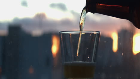 맥주는 초점이 흐려진 창에 대해 짧은 유리잔에 부어진다