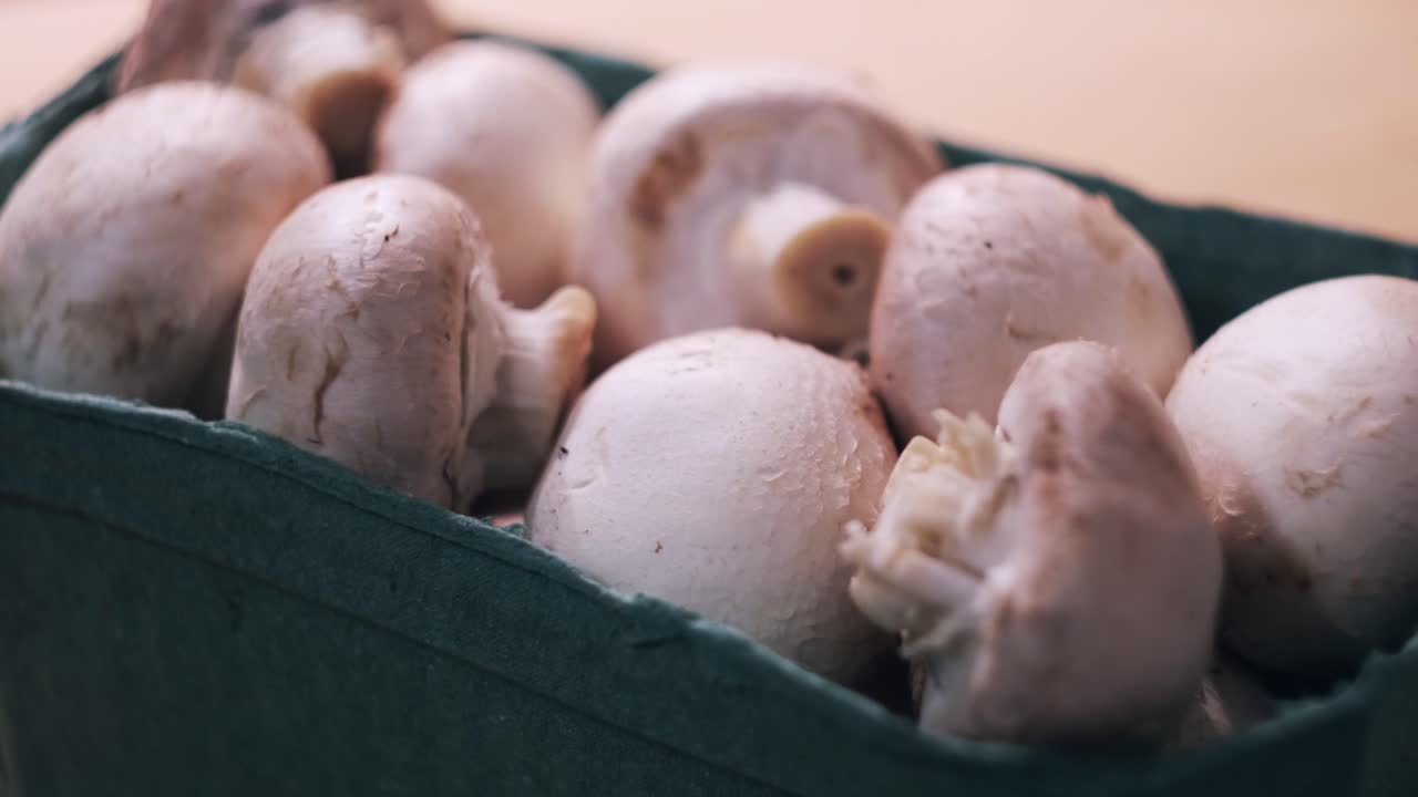 Hand Picking Fresh Mushrooms from a Box