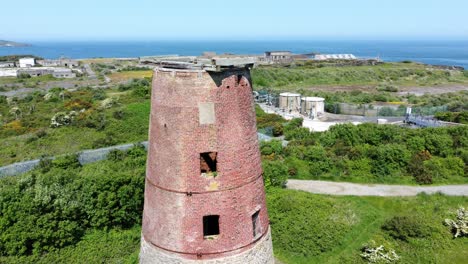 Amlwch-Puerto-Ladrillo-Rojo-En-Desuso-Abandonado-Molino-De-Viento-Vista-Aérea-Norte-De-Anglesey-Gales-Cerca-Orbitando-A-La-Derecha