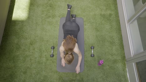 An-aerial-shot-of-a-woman-stretch-posing-in-her-back-yard-4k60