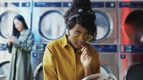 young beautiful girl in yellow glasses sitting in laundry service room