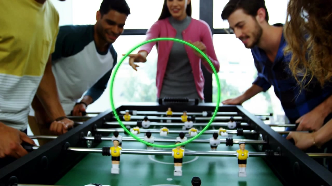 Animazione di un cerchio su un gruppo eterogeneo di persone d'affari che giocano a calcio balilla.