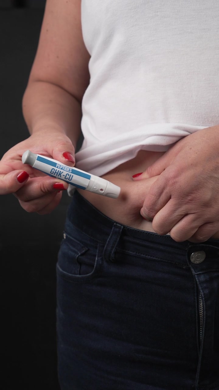Verticale. Donna di mezza età solleva la camicia bianca e inietta il peptide CHK-CU 10 nel grasso addominale con un iniettore a penna, utile per concetti medici, di diabete, obesità o terapia ormonale.