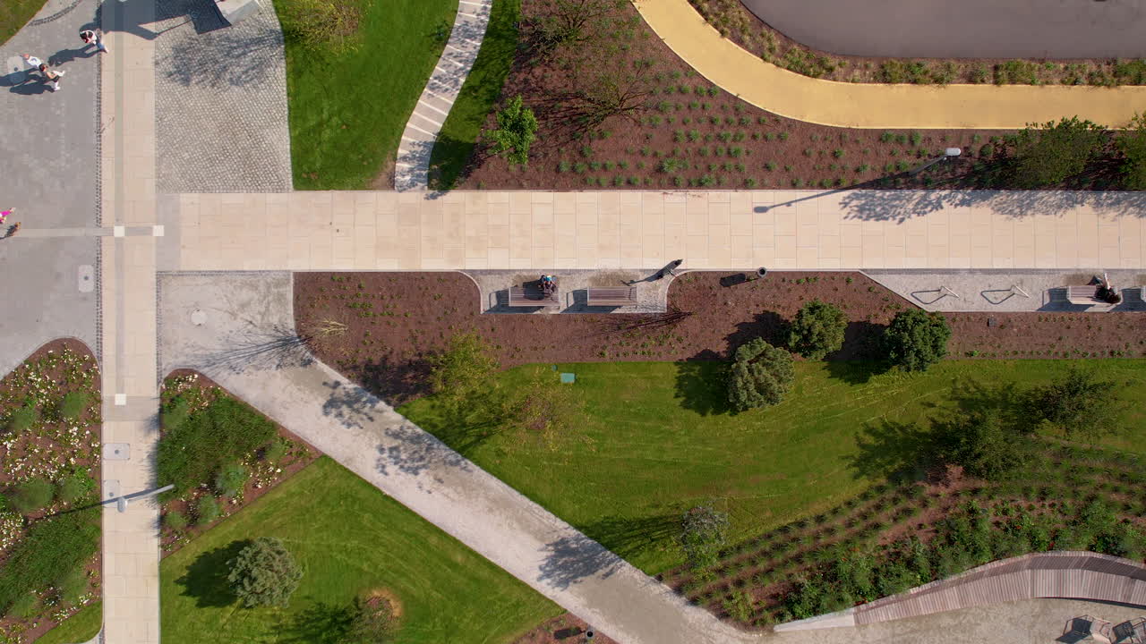 Top down aerial - several paths in the park, modern infrastructure in the park, greenery and development of urban area