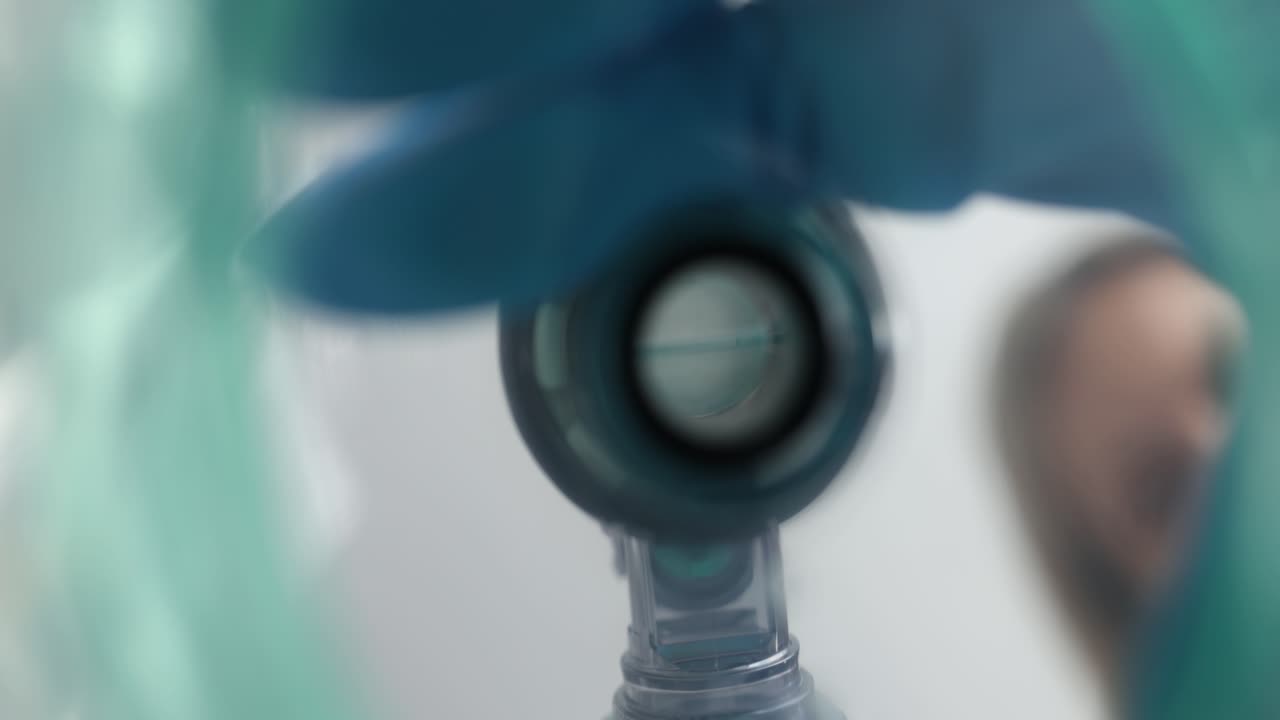 First-person view of a medical professional applying an oxygen mask