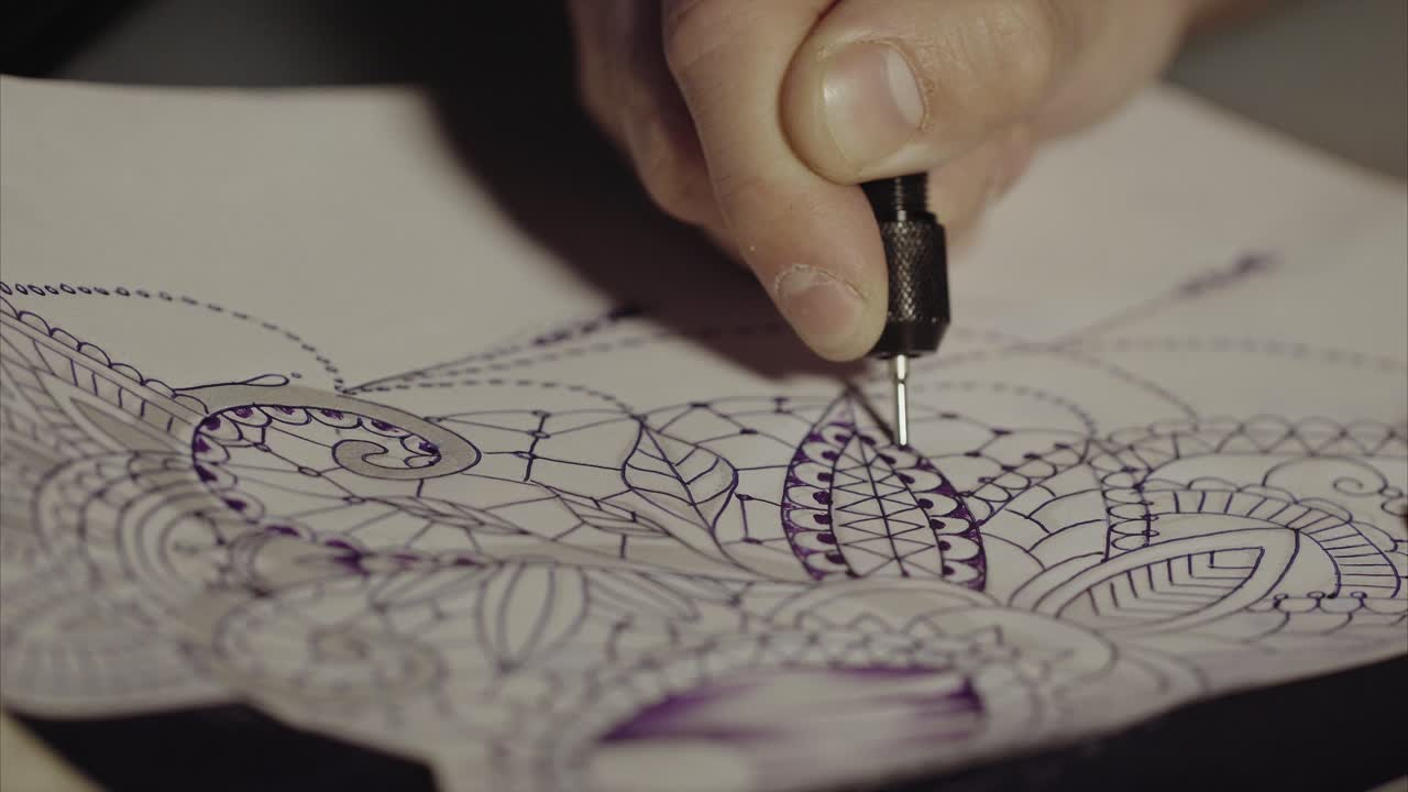 Tatuatore che disegna un tatuaggio