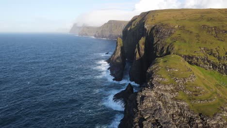 Ferne-Drohnenaufnahmen-Von-Steilen-Klippen-Mit-Aufgehender-Sonne-In-Der-Nähe-Des-Leitisvatn-Sees,-Auch-Bekannt-Als-Schwimmender-See,-Auf-Der-Insel-Vagar-Auf-Den-Färöer-Inseln