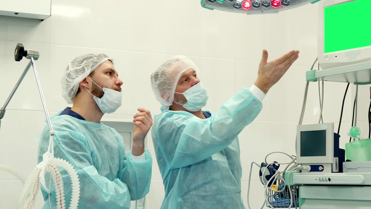 el cirujano señala su mano en el monitor