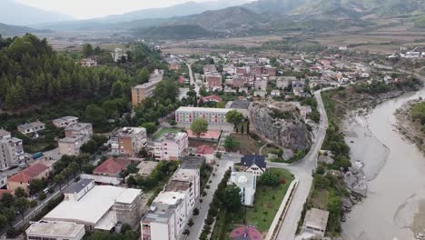 vista aérea del pueblo en albania, cerca de un río y un sitio de escalada en roca