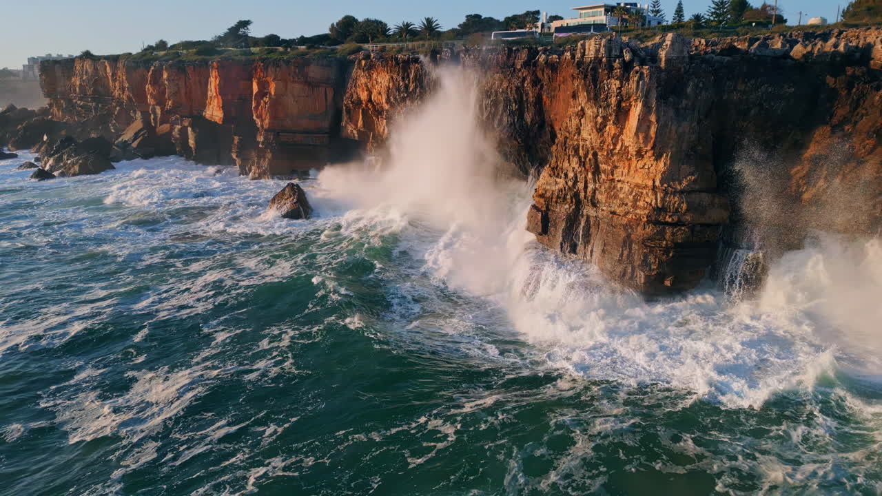 высокие океанские брызги разбиваются о прибрежные скалы. взгляд с воздуха. мощные морские волны.