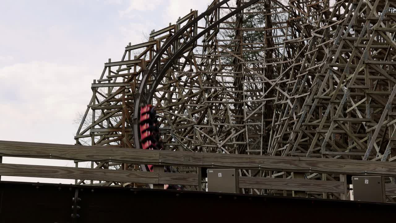 Dollywood visitors enjoy the thrills of speed, turns, drops and sudden stop on the Lightning Rod roller coaster. Wooden roller coaster with train moving on track and riders in cars.