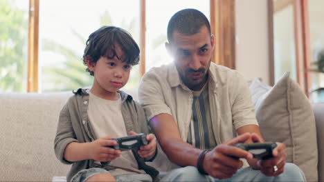 padre, niño y controlador de videojuegos en el sofá