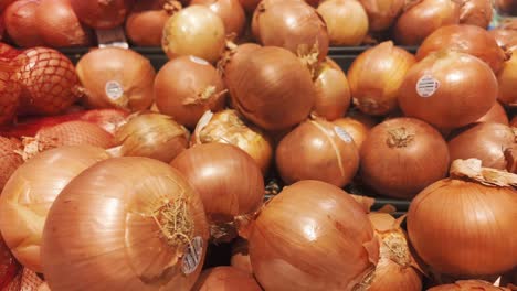 a pile of whole yellow onions at the farmer's market