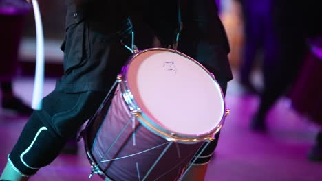 close up of a musician playing on a drum in a live concert